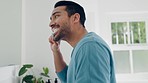 Dental health, wellness and man brushing teeth in the bathroom for morning grooming routine. Oral care, cleaning and young Indian male person doing a mouth treatment for hygiene in modern apartment.