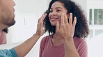 Face cream, happy and man doing skincare for his wife in the bathroom for wellness, love and bonding. Smile, grooming and young couple doing hygiene morning routine together on weekend in apartment.