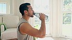 Fitness, drinking water and man in home, training and workout for healthy body. Liquid bottle, thirsty and hydration of athlete, nutrition diet and wellness on break to relax from sports or exercise