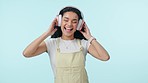 Dance, music and excited woman on headphones in studio isolated on a blue background mockup space. Radio, smile and person moving to audio, listening to sound and hearing hip hop, freedom and energy