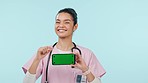 Nurse, presentation and phone green screen for healthcare advice, yes and good news or results in studio. Face of doctor, woman or medical student, mobile mockup or tracking marker on blue background