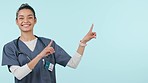 Doctor, healthcare and woman in studio pointing for medical care, service and yes for decision. Advertising, medicine and portrait of person on blue background for information, news and promotion