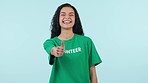 Volunteer, woman with thumbs up and face, help and activism with charity isolated on blue background. Happy, NGO and community service with support, yes emoji and mockup space with portrait in studio