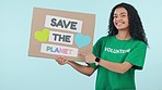 Woman, volunteer and poster, climate change and sustainability, activism and smile on blue background. Point at save the planet sign, Earth Day and charity, help and care with protest in studio