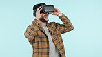 Young man, VR vision and glasses in software development, game test or user experience on blue background. Startup developer or IT person watch video in virtual reality or future technology in studio