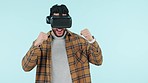 Man, winner and virtual reality glasses for gaming success, futuristic competition and celebration in studio. Excited, happy person of VR experience, winning and yes or achievement on blue background