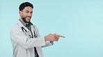 Doctor, man and pointing for healthcare presentation, clinic news or happy information mockup in studio. Face of medical professional marketing, choice and steps, guide or join us on blue background