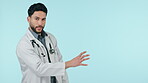 Medical doctor, talking and presentation of a man in studio for communication, consultation or speech. Arab healthcare worker with hand on blue background for telehealth consultation or mockup space