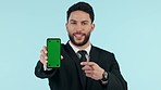 Happy businessman, phone and pointing to green screen in advertising against a studio background. Portrait of man or business employee show mobile smartphone app, display or recommendation on mockup