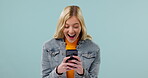 Student, woman wow and phone for social media, fake news or college information, results and surprise in studio. Excited young person on mobile, shocked for chat and communication on blue background