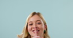 Secret, person and hands on lips in studio with whisper emoji for confidential, silence and shush mouth expression or face. Portrait, woman and gossip for surprise or announcement on blue background.