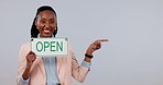 Happy black woman, small business and open sign pointing on mockup space against a studio background. Portrait of African female person smile and showing billboard or poster in ready for service