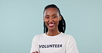 Black woman, volunteer and community service for charity and help, arms crossed and face in studio. Activism, support and mockup space with NGO, social responsibility and portrait on blue background