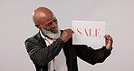 Sale, promo and senior black man with sign for promotion or poster for giveaway isolated in a studio grey background. Smile, happy and portrait of elderly person with discount or saving announcement