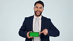 Face, business and man pointing to green screen of phone for advertising space, promotion or tracking markers in studio. Portrait, happy arab worker or mobile news, deal or mockup on white background