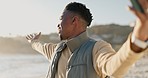 Happy, selfie and a black man at the beach for livestreaming, social media vacation or talking online. Smile, nature and an African influencer taking a photo at the sea with a broadcast on a mobile