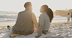 Smile, love and hugging with a black couple on the beach together at sunset for romance or dating from the back. Flare, ocean or holiday in summer with a man and woman sitting on the sand by the sea