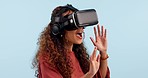 Woman, virtual reality glasses and studio with hands, gaming and press with 3D user experience by blue background. Girl, ar vision and click for metaverse, video game or esports with futuristic tech