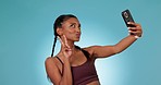 Woman, fitness selfie and studio with peace sign, pout lips or photography for smile by blue background. Influencer girl, emoji or icon with kiss, profile picture or post on web, social media or app