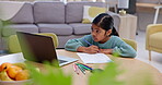 Girl, kid and laptop, education and online learning with writing, assessment and study at table in living room. Internet, student and homework online with activity on paper and school at home 