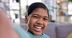 Selfie, face and smile with an indian girl child closeup in the living room of her home for playful recording. Portrait, cute and a happy young kid in her house for a video, movie or film for youth