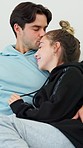 Couple, hug and kiss on sofa for love, care and relax together with trust, comfort and support at home. Happy man, young woman and embrace with affection, romance or loyalty to partner in living room