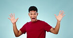 Face, wow and mind blown with the reaction of a man in studio on a blue background looking shocked at news. Portrait, alarm and surprise with a young person hearing a secret, announcement or gossip