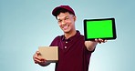 Tablet, green screen and delivery man in a studio with a cardboard box for ecommerce package. Tracking markers, chroma key and male courier with digital technology mockup space by blue background.