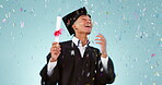 Graduation, student and man in confetti celebration, success and achievement of college or university in studio. Happy graduate dance for award, certificate or diploma in education on blue background