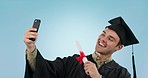 Graduation, man and studio selfie for diploma, pride or achievement of learning goal by blue background. University student guy, photography and happy for certificate, social media or profile picture