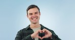 Heart, hands and face of happy man in studio with thank you, motivation or kindness gesture on blue background. Gratitude, support and portrait of male model with emoji hope finger frame and love