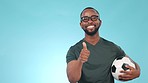 Thumbs up, soccer and black man catch ball happy for fitness or sports isolated in a studio blue background. Thank you, yes and young athlete or person in agreement of football success or goal