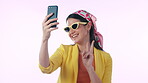 Selfie, smile and peace sign with a social media woman in studio on a blue background for a profile picture. Phone, smile and funny photo with a happy young influencer posing for a status update