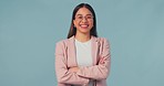 Face, smile and business woman with arms crossed in studio isolated on a blue background mockup space. Portrait, professional entrepreneur and confident corporate consultant in glasses in Brazil.