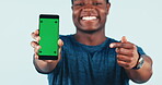 Man, pointing and portrait with green screen for mobile app in studio for fitness, training or online exercise program. Hand, gesture and athlete with phone chrome key for promotion or social media