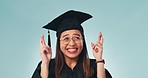 Graduation, university and education, happy woman with fingers crossed in studio for achievement or future career. Hope, opportunity and college girl with wish, scholarship dream and blue background.