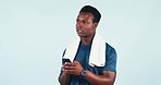 Man, thinking and typing with phone for exercise, fitness or workout information on blue background in studio. Sports, athlete or person search on internet with cellphone  communication or mobile app