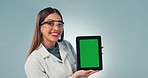 Scientist woman, tablet and green screen in studio with smile, face and review medical app by blue background. Doctor, digital touchscreen and mockup space with tracking markers for feedback on promo