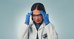 Doctor, woman and stressed with science in studio on blue background with for mockup, experiment or result. Female model, person and lab coat with gloves, glasses and headache in pain from research