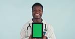 Portrait of doctor, black man with tablet and green screen in studio for telehealth, online healthcare and advice. Medical professional, caregiver or expert with digital health app on blue background