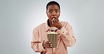 Woman, popcorn and scared of horror in studio, eating and mess with shock by white background. African girl, watch movie and surprise with fear, chaos or thriller in cinema, theater or television