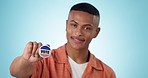 Man, vote and badge in hand for politics, freedom or democracy in studio for promo by blue background. Guy, pin and face for party, election campaign or choice for government, country or constitution