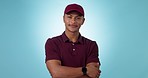 Portrait, delivery and man in studio with smile, confidence and pride, happy worker with logistics career. Courier person with arms crossed on blue background, transport service and in distribution.