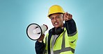 Builder man, megaphone and shout in studio, pointing and protest for human rights in workplace by blue background. Construction worker, leader face and bullhorn for speech, opinion or salary increase