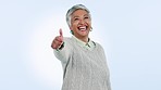Face, smile and senior woman with thumbs up, agreement and promotion on blue studio background. Portrait, mature person or happy model with hand gesture, icon and feedback with review, emoji and like