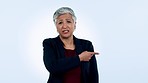 Pointing, disagree and a mature business woman in studio on blue background for a negative review or feedback. Portrait, management and bad news with an elderly employee giving a professional opinion