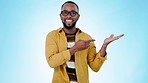 Face, happy man and advertising space in studio for mockup, announcement and promotion on blue background. Portrait, excited black model and pointing to palm for deal, launch and show news of sales