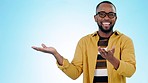 Black man, pointing at mockup and advertising presentation, information or news with ambassador on blue background. Portrait, branding and launch announcement with marketing and logo in a studio