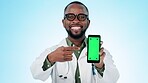 Doctor, face or green screen of smartphone in studio for advertising, sign up or show telehealth newsletter on blue background. Portrait, happy black man and mobile tracking markers of medical review