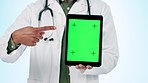 Doctor, hands and green screen of tablet in studio for advertising healthcare app, advice or telehealth newsletter on blue background. Closeup, medical person and pointing to digital tracking markers